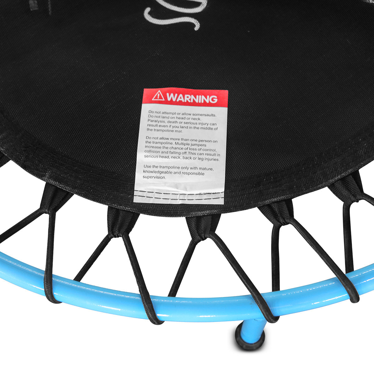 Close-up of a trampoline with a warning label on a black background