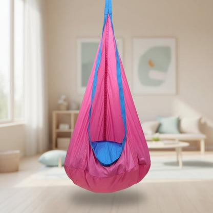 Pink and blue sensory hanging chair on a wooden deck with outdoor furniture and plants in the background.