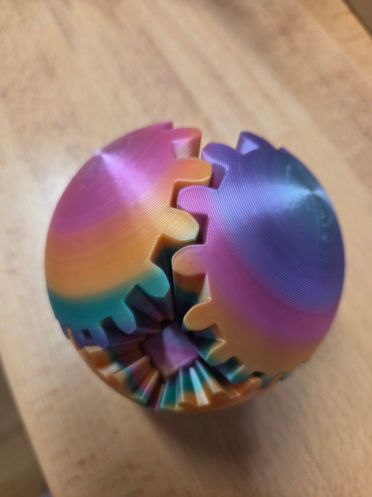 Colorful gear-shaped fidget ball on a wooden surface