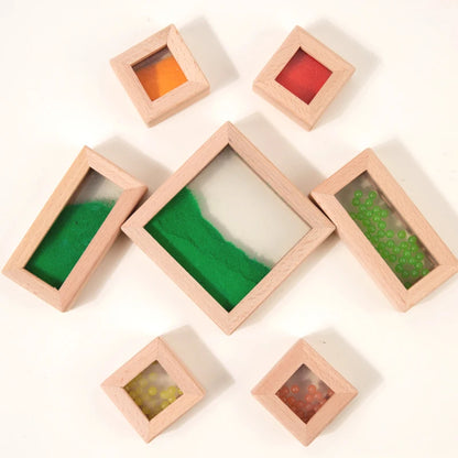 Set of wooden frames with colorful sand inside on a white background