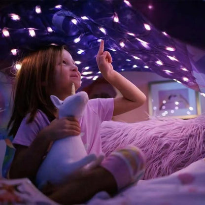 Child lying under starry light bed tent