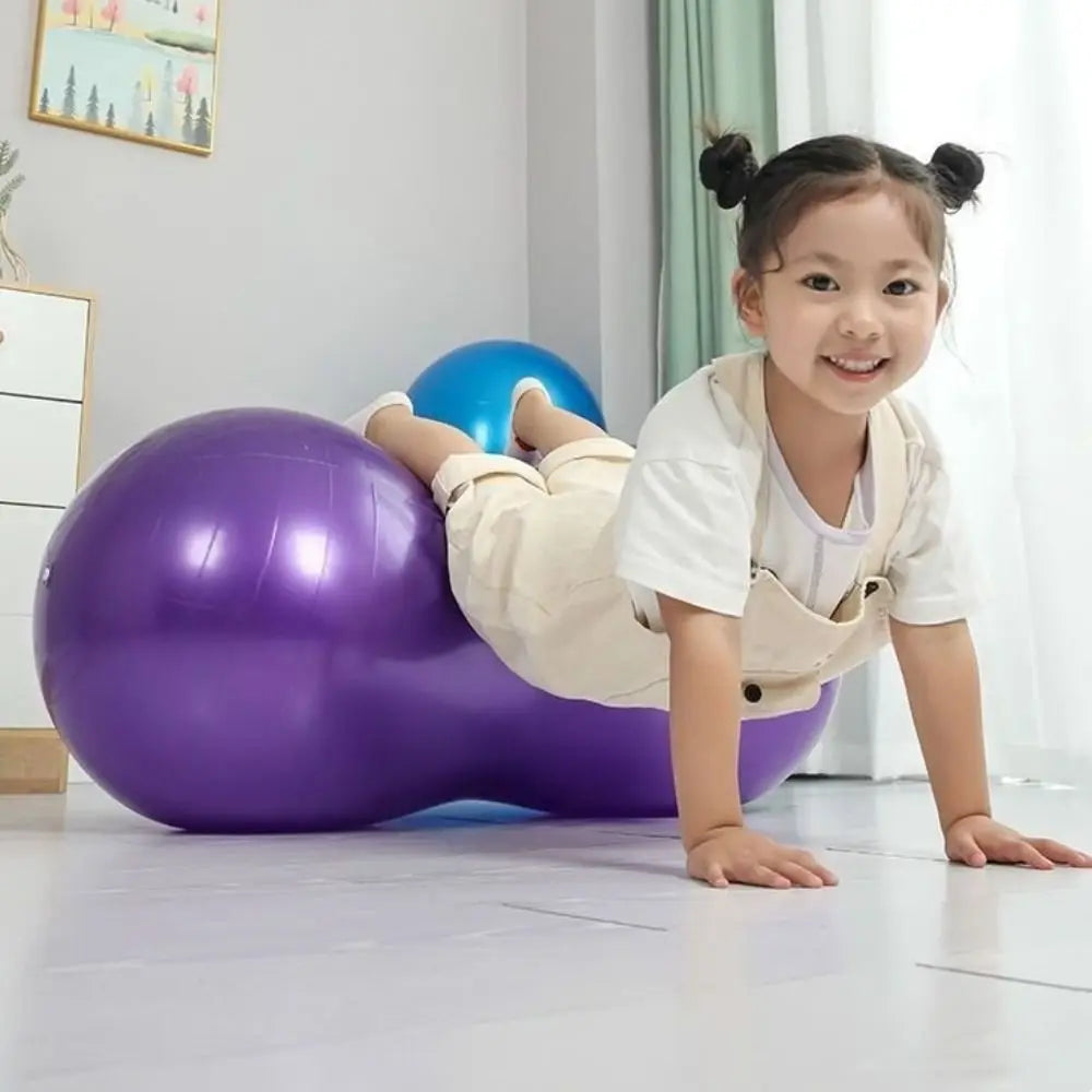 Child playing with exercise balls on a light-colored floor.