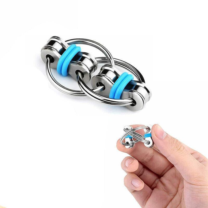 Metal finger puzzle toy with blue accents held by a hand on a white background