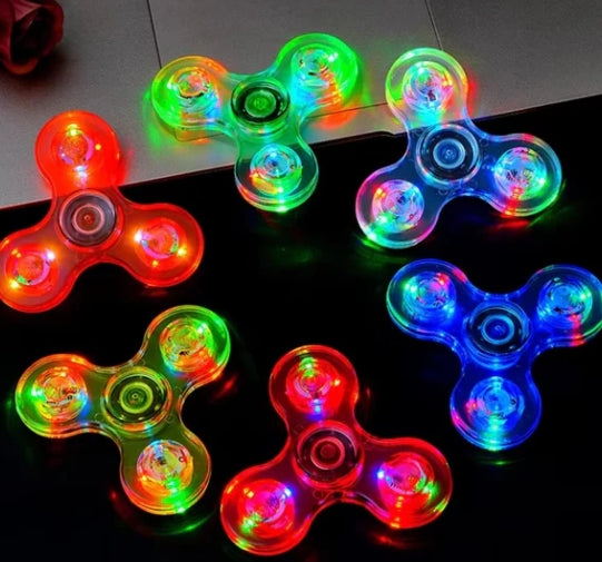 Colorful LED fidget spinners on a dark surface