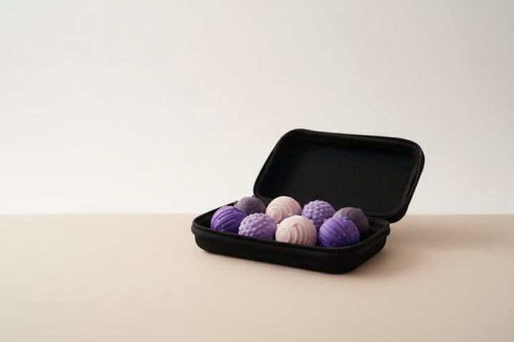 Black case with purple and pink textured balls on a light wooden floor.