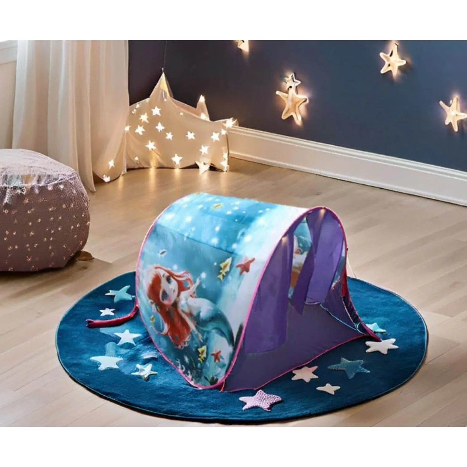 Children's play tent with mermaid design on a star-patterned mat in a room decorated with star lights.