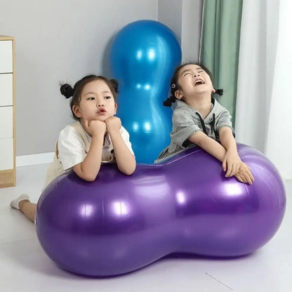 Two children sitting on a purple inflatable peanut ball with a blue peanut ball behind them.