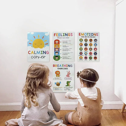 Two children sitting on the floor looking at educational posters on a wall.