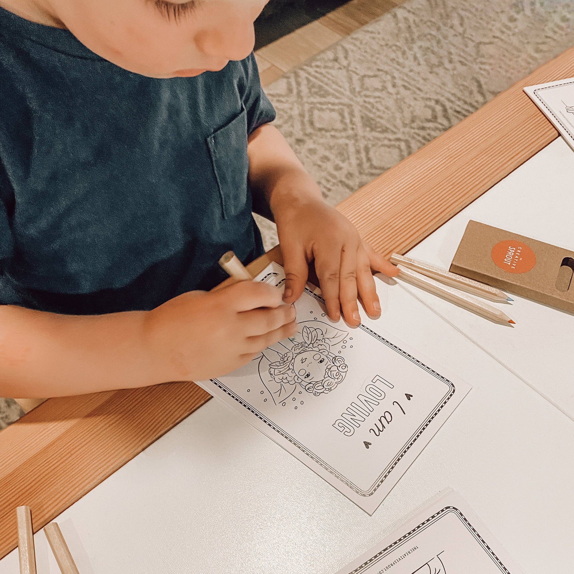 Child coloring a picture with markers on a table