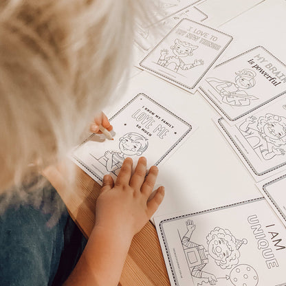 Child coloring a sheet with various illustrations and text