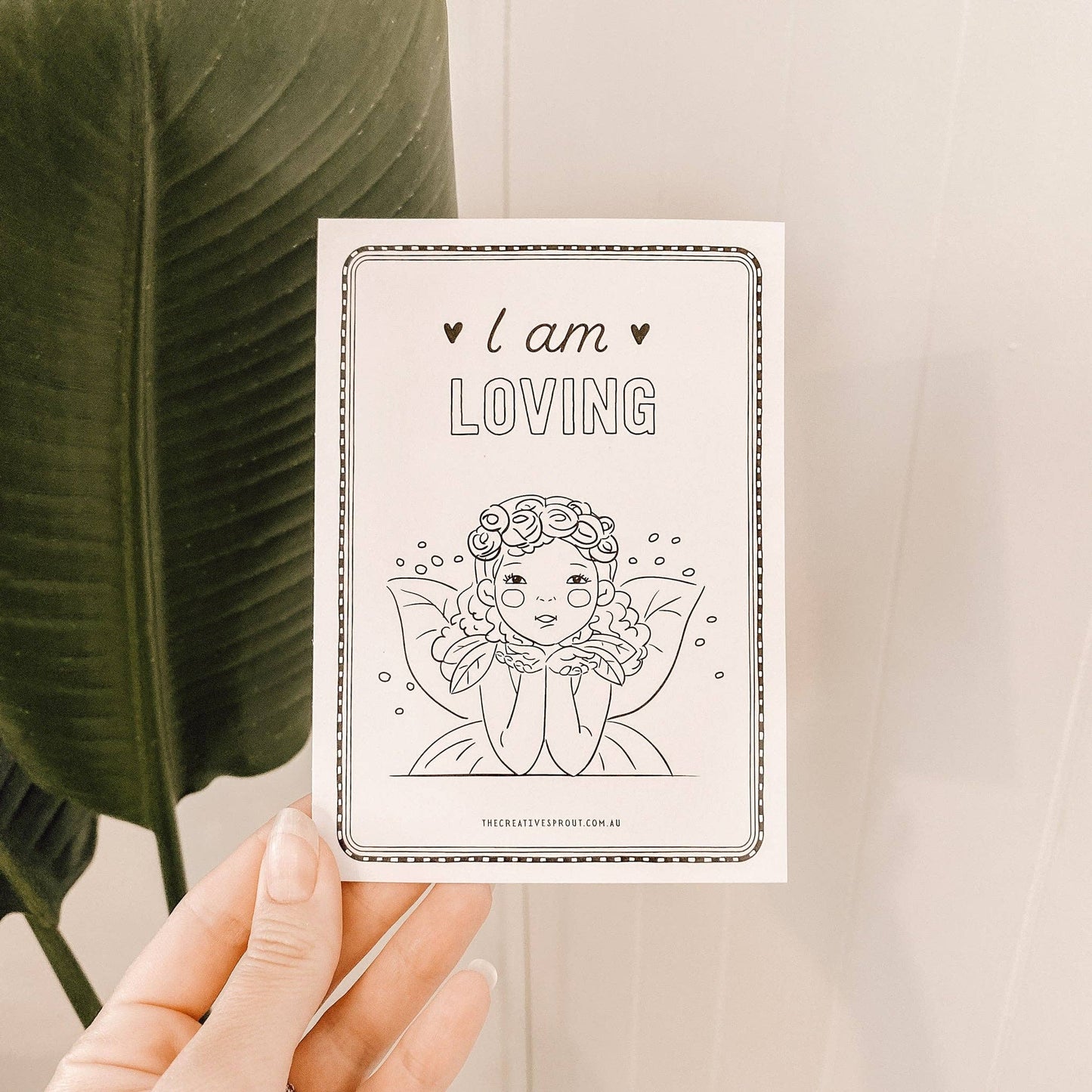 Card with 'I am LOVING' text and a line drawing of a woman held by a hand.