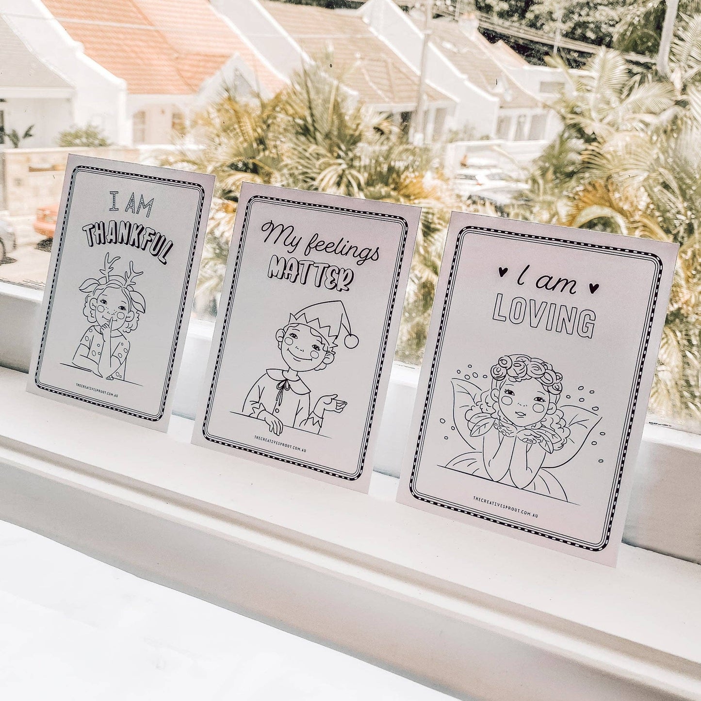 Three framed prints with motivational phrases on a windowsill.