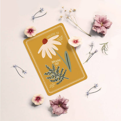 Card with floral design and text 'Breathe Out' surrounded by flowers on a light background