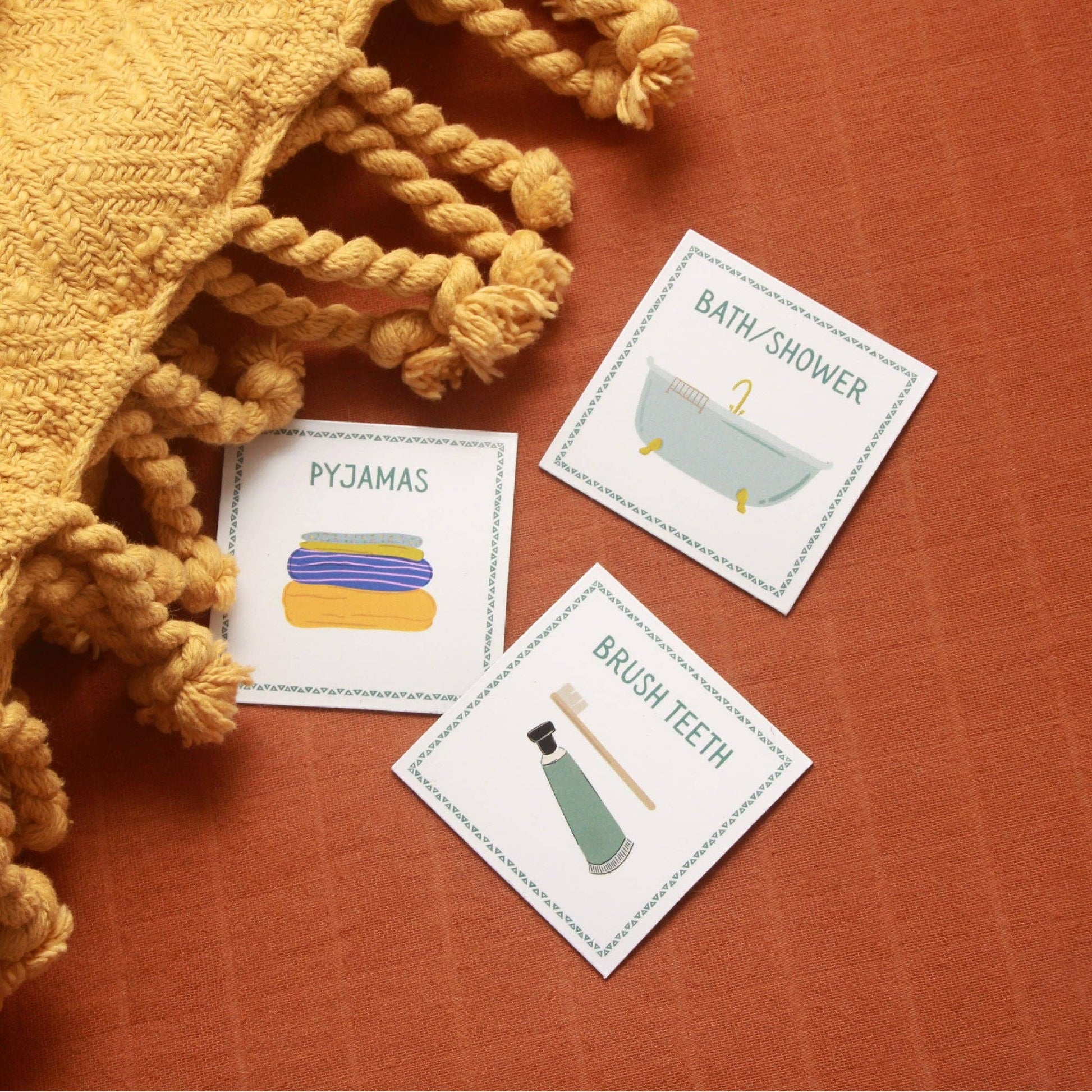 Three educational cards about bedtime routine on a textured surface with a yellow blanket.