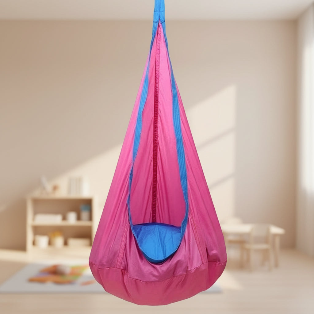 Pink and blue hanging sensory chair on a wooden deck with outdoor furniture and plants in the background.