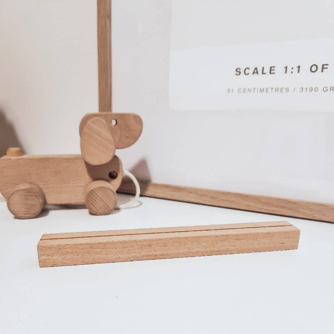 Wooden toy dog and ruler on a white surface with text indicating scale.